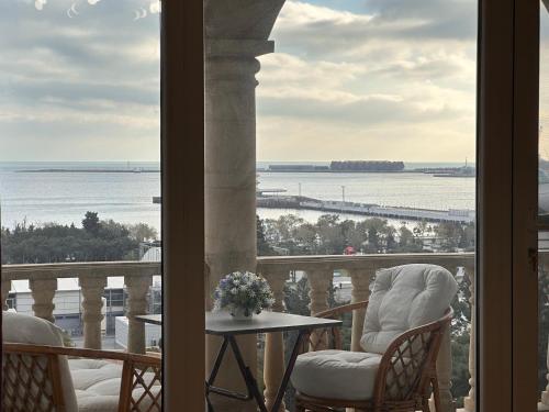a balcony with chairs and a table and a view of the water at Sea view Residence in Baku