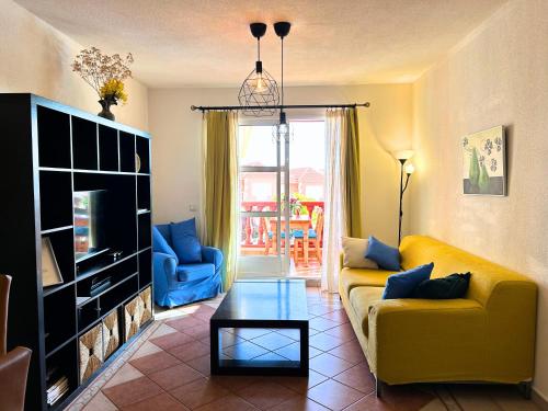 a living room with a yellow couch and a tv at Nice apartment Duque Tenerife South in Adeje