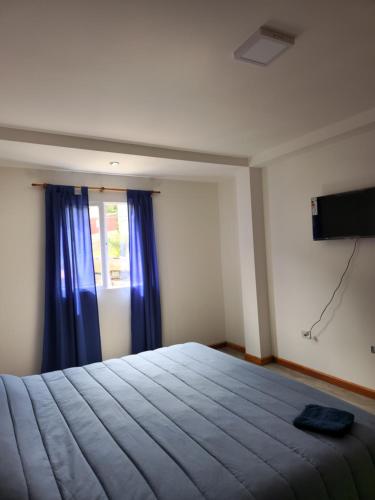 1 dormitorio con 1 cama grande y TV en Apartamento Bosques de los Andes en Ushuaia