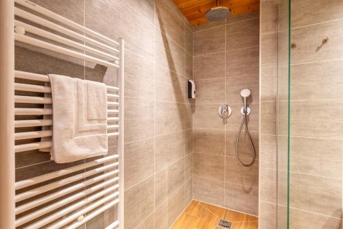 La salle de bains est pourvue d'une douche avec une porte en verre. dans l'établissement TARDEVANT 21, au Grand-Bornand