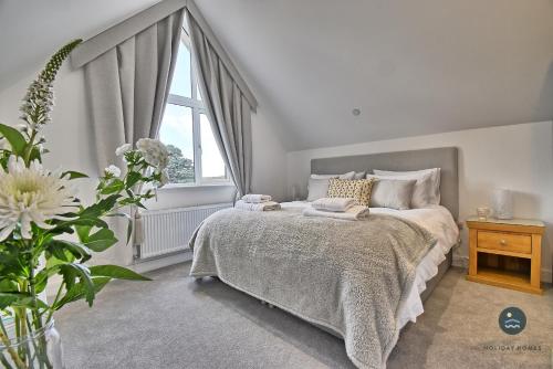 a bedroom with a bed and a window at Days Away - Luxury holiday home in Radipole
