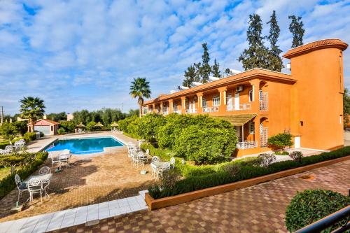 a large house with a swimming pool in the yard at Complexe El Bassatine in Beni Mellal