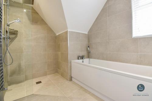 a bathroom with a shower and a bath tub at Days Away - Luxury holiday home in Radipole