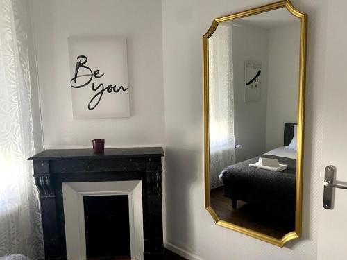 einen Spiegel in einem Zimmer mit einem Bett und einem Kamin in der Unterkunft Fée clochette # Centre de Reims in Reims