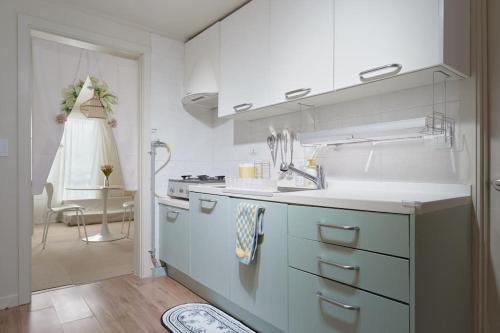 a white kitchen with a sink and a stove at Seoul Sensibility B&B House in Seoul