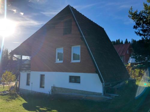 uma casa com um telhado de gambrel em cima dela em Mountain resort house-Planinska vikendica em Han Pijesak