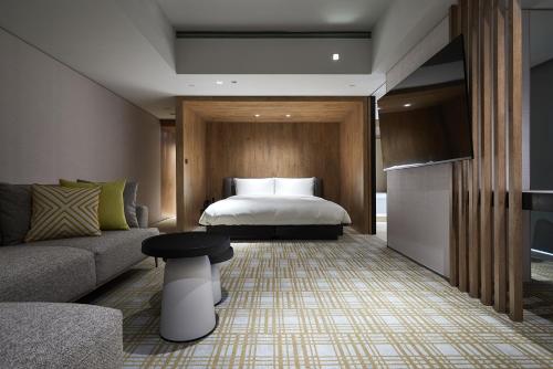 a hotel room with a bed and a couch at K Hotel Taipei Nanjing in Taipei