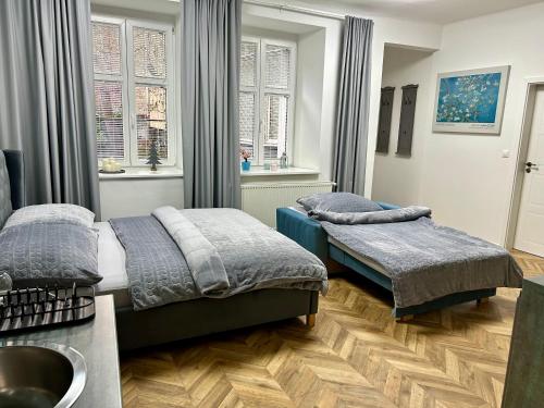 a bedroom with two beds and a sink at Almond Studio Apartment in Bratislava