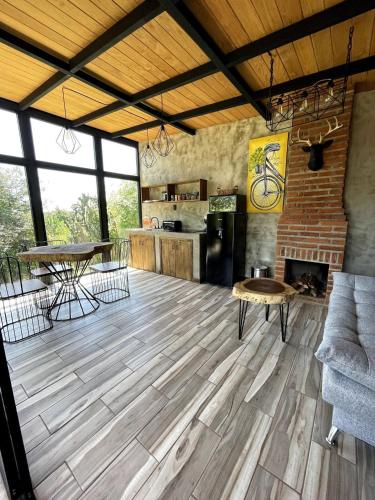 a living room with a wooden floor and a table at Cabaña Buganvilia, Tapalpa in Tapalpa