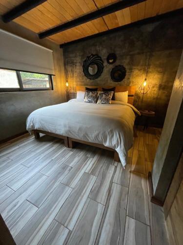 a bedroom with a bed and a wooden floor at Cabaña Buganvilia, Tapalpa in Tapalpa