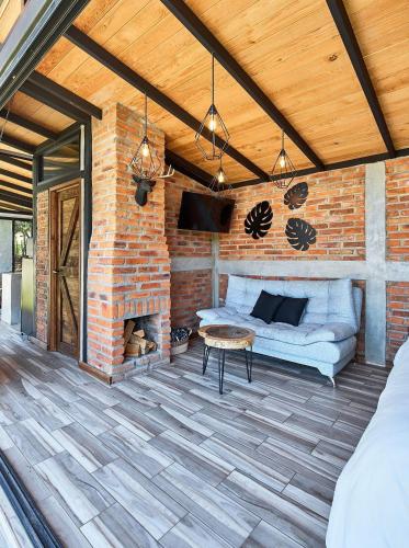 a brick patio with a couch and a fireplace at Cabaña Gardenia, Tapalpa in Tapalpa
