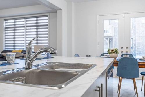 a kitchen with a stainless steel sink and blue chairs at Custom Build 5 Bedroom Villa (Ski Resort) in Midhurst