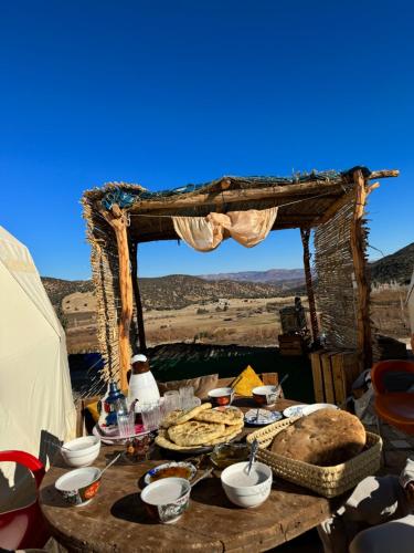 uma mesa com comida na frente de uma tenda em Eagles Dôme em Bou Tferda