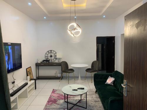 Luxury apartments في إيبادان: غرفة معيشة مع أريكة خضراء وطاولة