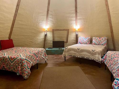 Zimmer mit 2 Betten und einem Spiegel in der Unterkunft Deer Run - Tipi 2 in New Braunfels