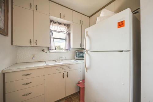 a kitchen with a white refrigerator and a sink at Rustic and Western House on Lake - Swim and Fish! in Llano