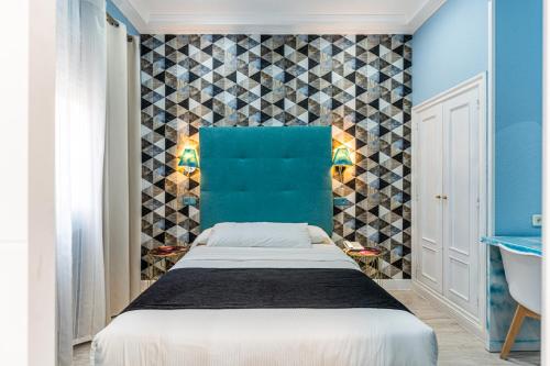 a bedroom with a bed and a blue wall at Hotel Mexico in Madrid