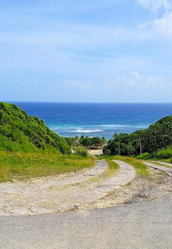 a dirt road with the ocean in the background at Maison spacieuse à Petit Canal, 104 m², proche sites historiques in Petit-Canal