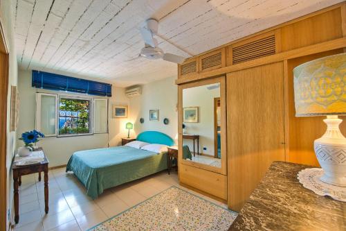 a bedroom with a bed and a window and a table at Luxury villa, pool, sea access, large terraces, stupendous views in Furore