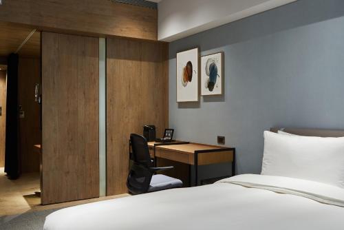 a hotel room with a bed and a desk at K Hotel Taipei Nanjing in Taipei