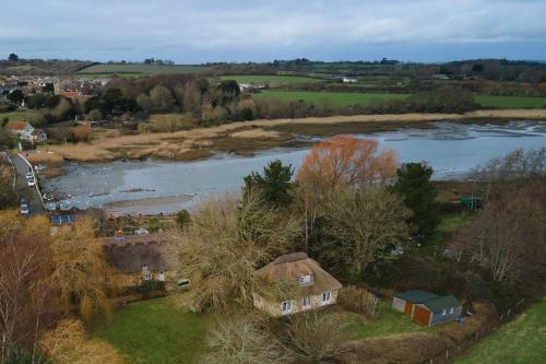 an aerial view of a river and a village at The Lodge: Adorable, Romantic Thatched Cottage in Freshwater