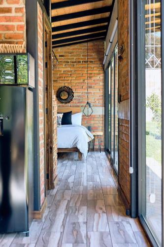 a room with a bed on a brick wall at Cabaña Lavanda, Tapalpa in Tapalpa