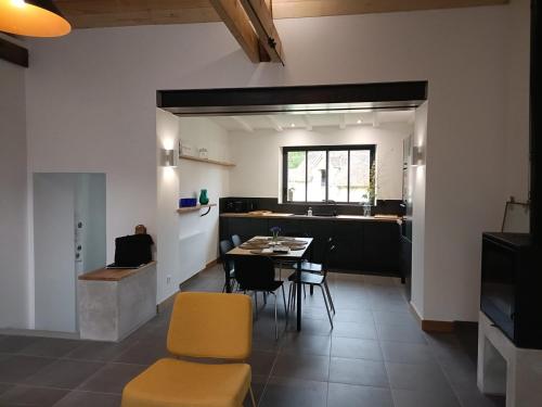 Longère Mille et une roses في Chédigny: مطبخ وغرفة طعام مع طاولة وكراسي