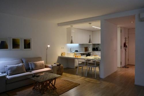 a living room and kitchen with a couch and a table at Del Mar Village, Apartment T1 , Açor in Fuzeta