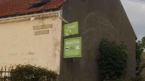 un panneau vert sur le côté d'un bâtiment dans l'établissement Chambres et Table d'hôtes Cerviña, à Châteauneuf-sur-Loire