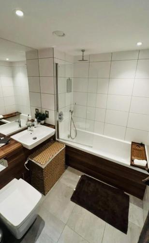 a bathroom with a tub and a toilet and a sink at Trendy & Chic Apartment In The Heart of London in London