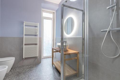 ein Bad mit einer Dusche, einem WC und einem Waschbecken in der Unterkunft ALTIDO Trendy units in the city centre in Triest