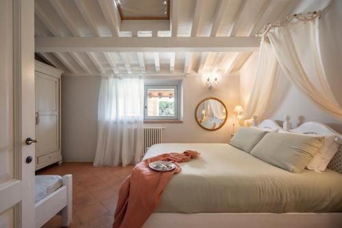 una camera da letto con un grande letto bianco e uno specchio di Il Cantinone a San Vincenzo