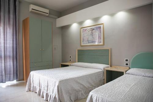 una camera d'albergo con due letti e una finestra di Maximo Hotel a Tivoli Terme