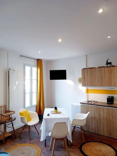 Zimmer mit einem Tisch und Stühlen sowie einer Küche in der Unterkunft Maisonnette Cosy wifi gratuit Rochefort in Rochefort