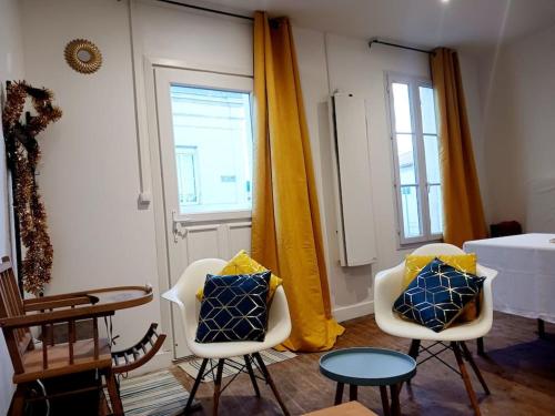 ein Wohnzimmer mit 2 Stühlen und einem Tisch in der Unterkunft Maisonnette Cosy wifi gratuit Rochefort in Rochefort