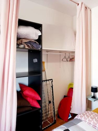 Zimmer mit einem Bett und einem Schrank mit roten Kissen in der Unterkunft Maisonnette Cosy wifi gratuit Rochefort in Rochefort