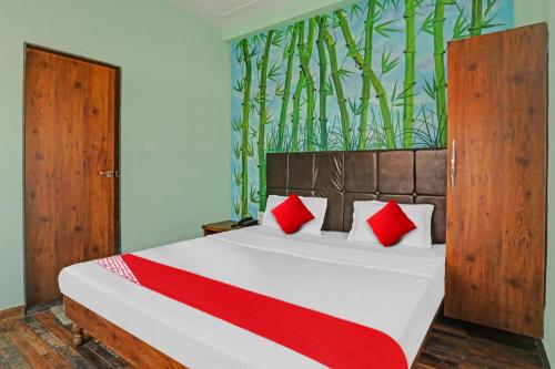 1 dormitorio con 1 cama grande con almohadas rojas en OYO Flagship MH Inn en Varanasi