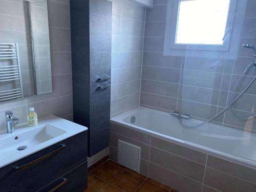 une salle de bain avec une baignoire et un lavabo dans l'établissement 4MIR11BLEU - Appartement pour 4 personnes T2 en duplex tout confort, à Collioure