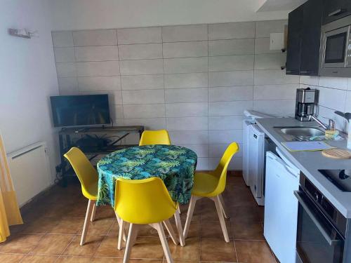 une petite cuisine avec une table et des chaises jaunes dans l'établissement 4MIR11JAUNE- T2 en DUPLEX idéalement situé pour 4 personnes, à Collioure