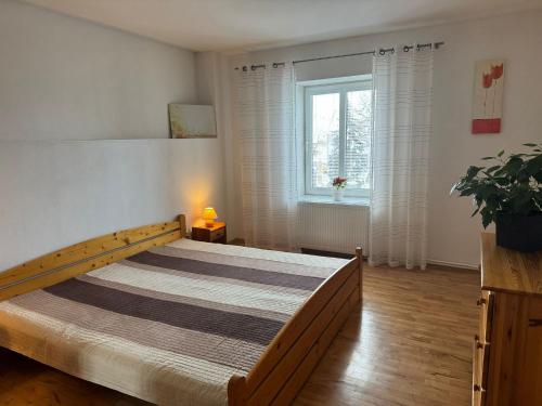 a bedroom with a large bed in a room with a window at Apartmán Rebeka in Liptovský Mikuláš