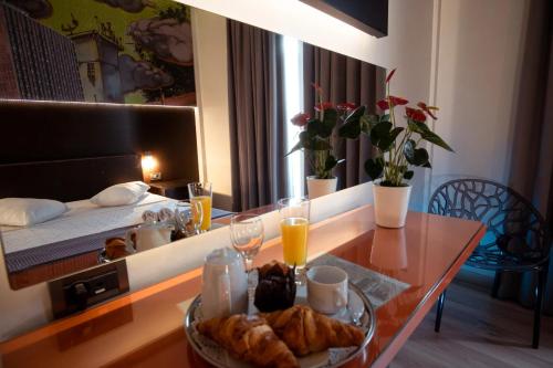 a table with a plate of food on it in a room at Athens City Hotel in Athens