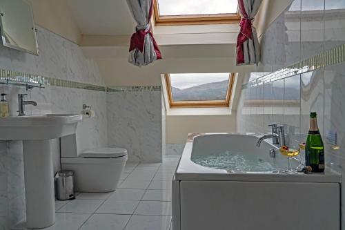 uma casa de banho com uma banheira, um WC e um lavatório. em Newton Hall em Inveraray