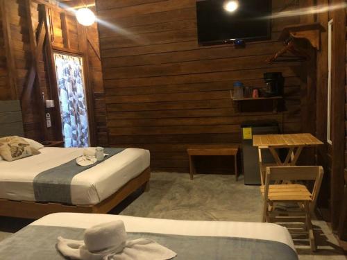 a bedroom with two beds and a hat on top of it at Caba&ntilde;as Chac Mool Downtown in Holbox Island