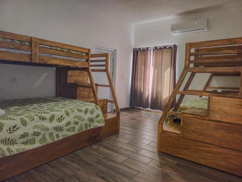 1 dormitorio con 2 literas y suelo de madera en Villa Juliana Monterrico, en Taxisco