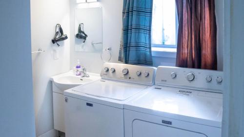 a bathroom with a washing machine and a sink at Lovely 1-BR W Sofa Bed in The Heart of NDG in Montréal