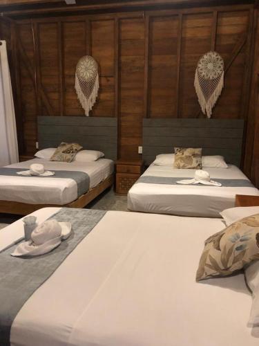 2 Betten in einem Zimmer mit Hüten und Handtüchern darauf in der Unterkunft Cabañas Chac Mool Downtown in Holbox