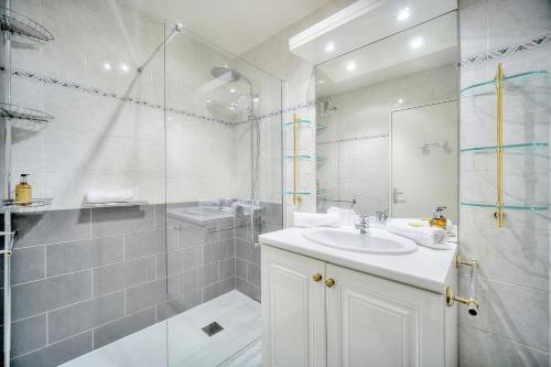 une salle de bain blanche avec un lavabo et une douche dans l'établissement IMMOGROOM - Sea view - Swimming Pool - Terrace- Clim, à Cannes