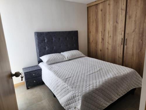 a bedroom with a bed and a wooden cabinet at cómodo apartamento en Copacabana in Copacabana