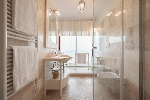 y baño con lavabo, aseo y ducha. en Corso Emanuele Apartments, en San Vincenzo