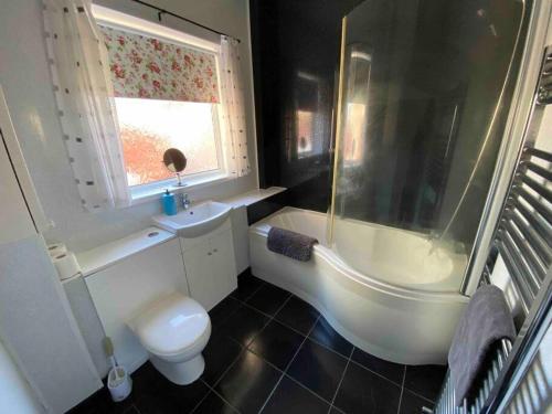 een badkamer met een bad, een toilet en een wastafel bij East Stay 2/3 bedroom Flat in Westoe